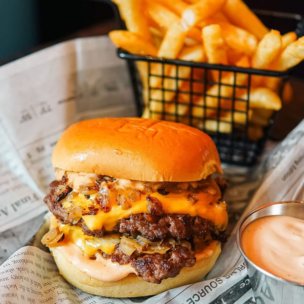 Haazs double cheeseburger with caramelized onions, special sauce, and a side of fries.